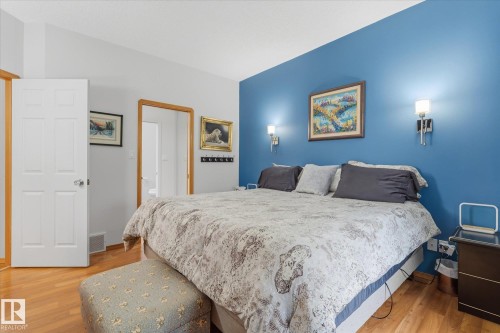 Hardwood-finish flooring, accent wall, and built-in wall sconces - 7 Linkside Pl, Spruce Grove, AB 