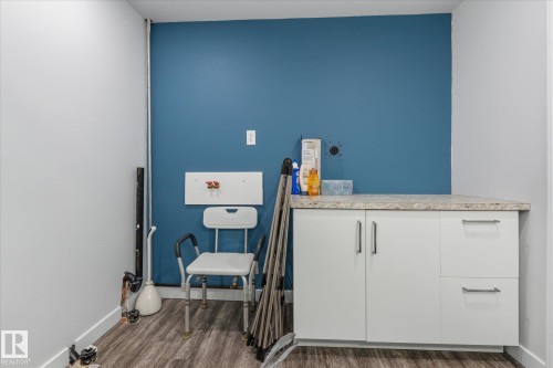 Built-in cabinetry with a stone-finish countertop, wood-finish flooring, and a dedicated appliance hookup - 7 Linkside Pl, Spruce Grove, AB 