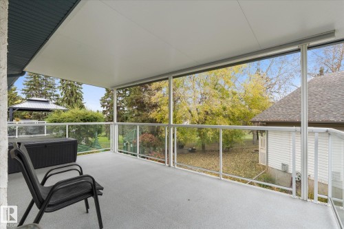 Covered balcony with a glass railing system and a gray textured floor - 7 Linkside Pl, Spruce Grove, AB 