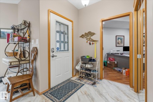 White front entry door with a multi-pane window, light wood door trim, and a surface-mounted ceiling light fixture - 7 Linkside Pl, Spruce Grove, AB 