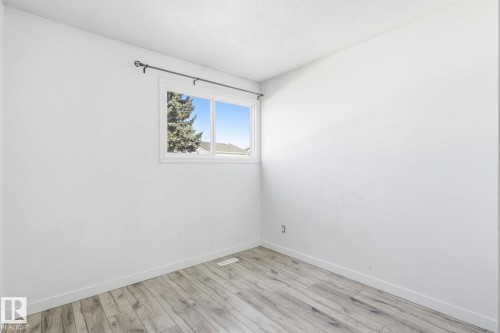 Wood-finish flooring with white walls and a window featuring a white frame - 164 Dickinsfield Court Nw, Edmonton, AB 