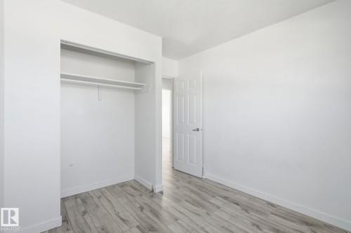 Wood-finish flooring with white walls - 164 Dickinsfield Court Nw, Edmonton, AB 