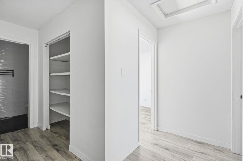 Wood-finish flooring throughout, bright white walls, and built-in shelving - 164 Dickinsfield Court Nw, Edmonton, AB 