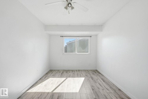 White walls with wood-finish flooring, a ceiling fan, and a window with blinds - 164 Dickinsfield Court Nw, Edmonton, AB 