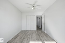 Room featuring wood-finish flooring, white walls, a ceiling fan with integrated lighting, and a bi-fold closet door - 