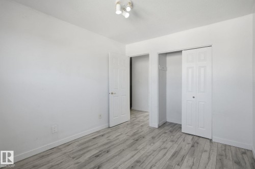 Wood-finish flooring, white walls, interior doors, bi-fold closet doors, and overhead track lighting - 164 Dickinsfield Court Nw, Edmonton, AB 