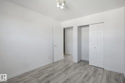 Wood-finish flooring, white walls, interior doors, bi-fold closet doors, and overhead track lighting - 
