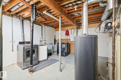 Exposed wood beam ceiling, concrete flooring, and utility sink - 164 Dickinsfield Court Nw, Edmonton, AB 