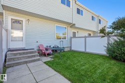 Private outdoor space with a manicured lawn, concrete patio, and privacy fencing - 