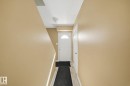 Entryway featuring a white door with an arched window insert, wood-finish flooring, and light-toned wall paint - 164 Dickinsfield Court Nw, Edmonton, AB 