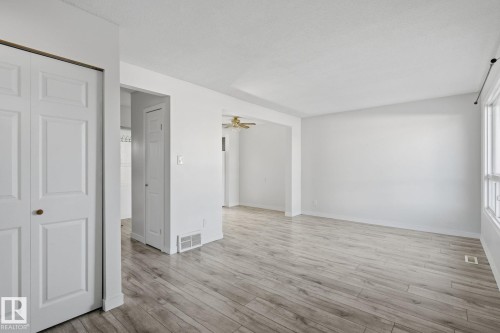 Bright interior with wood-finish flooring, white walls, and a prominent window - 164 Dickinsfield Court Nw, Edmonton, AB 