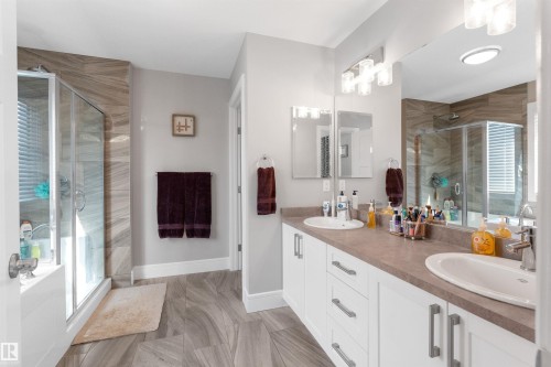 Dual vanity with integrated sinks, white cabinetry, and brushed nickel hardware - 3334 Parker Loop Sw, Edmonton, AB 