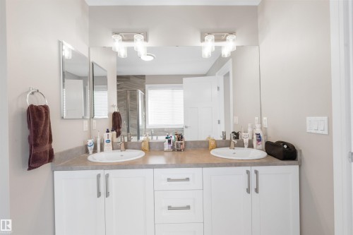 Dual vanity with undermount sinks, white cabinetry, and brushed nickel hardware - 3334 Parker Loop Sw, Edmonton, AB 