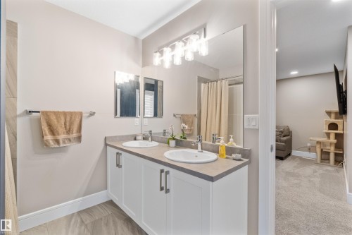 Double vanity with white cabinetry, light countertops, and individual undermount sinks - 3334 Parker Loop Sw, Edmonton, AB 
