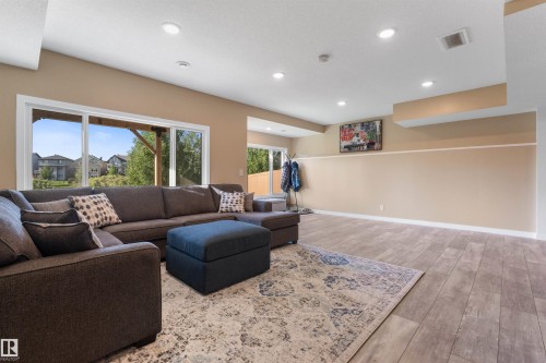 Expansive room featuring wood-finish flooring and LED lighting. - 3334 Parker Loop Sw, Edmonton, AB 