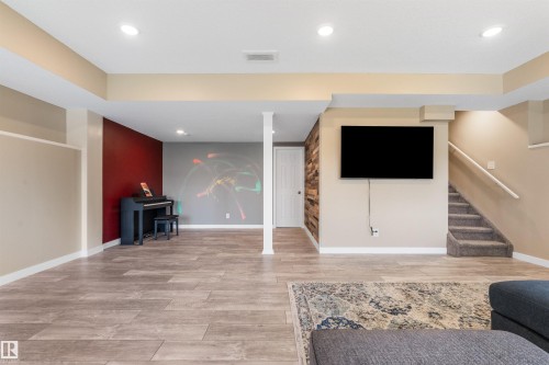 Recessed lighting, wood-finish flooring, accent wall, wood-paneled wall feature, and carpeted stairs - 3334 Parker Loop Sw, Edmonton, AB 