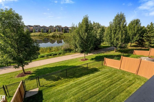 Expansive green lawn with a chain-link fence and wood privacy fencing - 3334 Parker Loop Sw, Edmonton, AB 