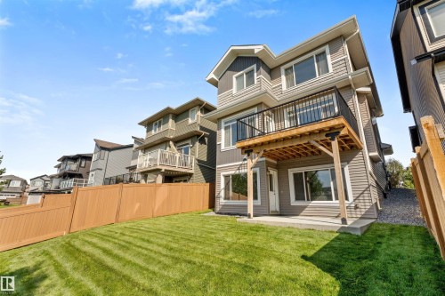 Expansive backyard with a manicured lawn, full privacy fencing, and a ground-level patio - 3334 Parker Loop Sw, Edmonton, AB 