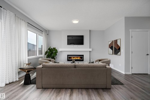 Wood-finish flooring, recessed lighting, and a built-in fireplace with a mantel - 9227 223 Street Nw, Edmonton, AB 