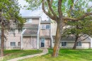 Exterior featuring beige siding, multiple windows, a paved walkway, and a sloped roof - #6 3819 76 St Nw, Edmonton, AB 