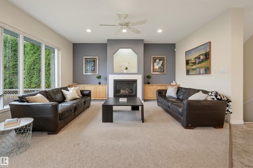 Living area featuring a fireplace with a white mantel, recessed lighting, and a ceiling fan - 7521 111 Avenue Nw, Edmonton, AB 