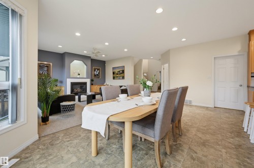 Recessed lighting, wood-finish flooring, a white window frame, and a fireplace with a white mantel and hearth - 7521 111 Avenue Nw, Edmonton, AB 