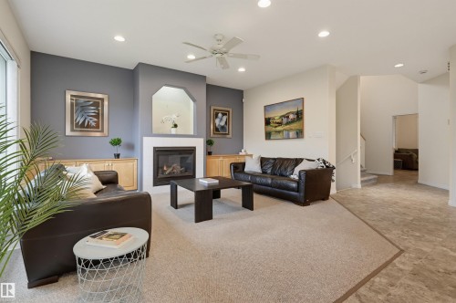Carpeted living area with a built-in fireplace, recessed lighting, and a ceiling fan - 7521 111 Avenue Nw, Edmonton, AB 