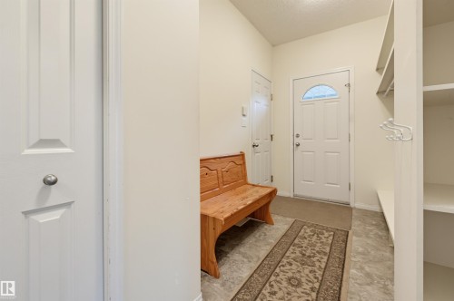 Entryway featuring solid core doors, built-in shelving, and tile flooring - 7521 111 Avenue Nw, Edmonton, AB 