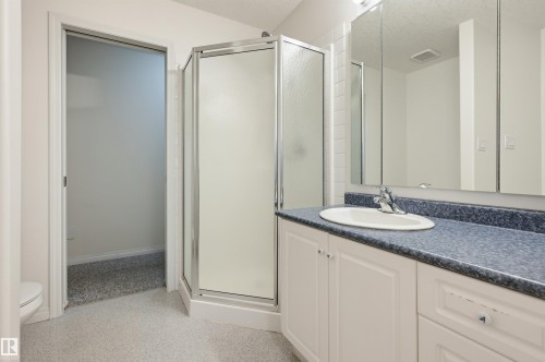 Vanity with an integrated sink, polished chrome faucet, and a large mirror - 7521 111 Avenue Nw, Edmonton, AB 