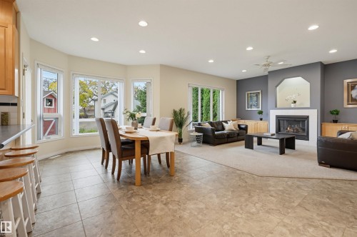 Open-concept living space with recessed lighting, a built-in fireplace, tile flooring, and multiple windows - 7521 111 Avenue Nw, Edmonton, AB 