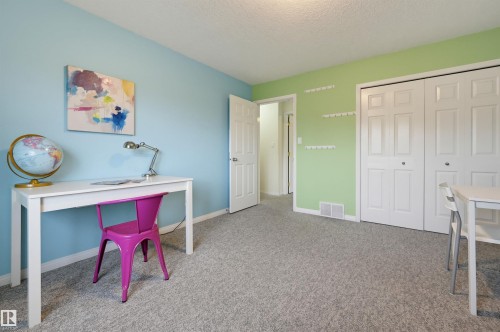 Plush gray carpeting throughout, featuring bi-fold closet doors and a paneled interior door - 7521 111 Avenue Nw, Edmonton, AB 