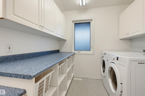 White upper cabinetry, extensive countertop space, integrated shelving, and a single window - 7521 111 Avenue Nw, Edmonton, AB 