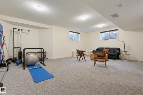 Spacious lower level featuring light-colored walls and grey carpeting - 7521 111 Avenue Nw, Edmonton, AB 