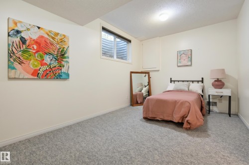 Neutral wall finishes, textured ceiling, light-colored carpeting, and a window with security bars - 7521 111 Avenue Nw, Edmonton, AB 