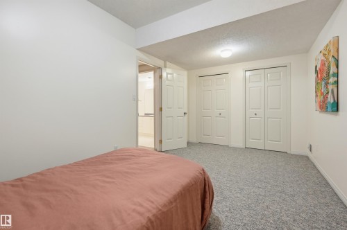 Wall-to-wall carpeting with two bi-fold door closets, recessed lighting, and white painted walls - 7521 111 Avenue Nw, Edmonton, AB 