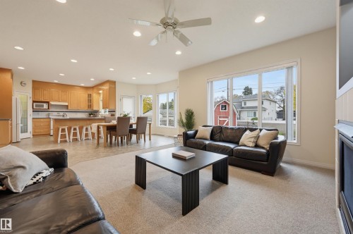 Open-concept living space featuring a ceiling fan with light fixture, recessed lighting, and large windows - 7521 111 Avenue Nw, Edmonton, AB 