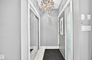 Entryway featuring a decorative pendant light, a gray entry door with leaded glass, and a mirrored closet - 12730 118 Street Nw, Edmonton, AB 