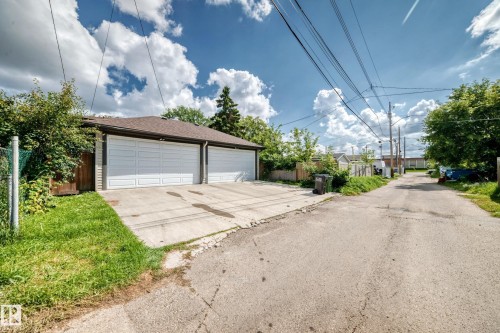 Detached garage with two white overhead doors and concrete drive - 12730 118 Street Nw, Edmonton, AB 
