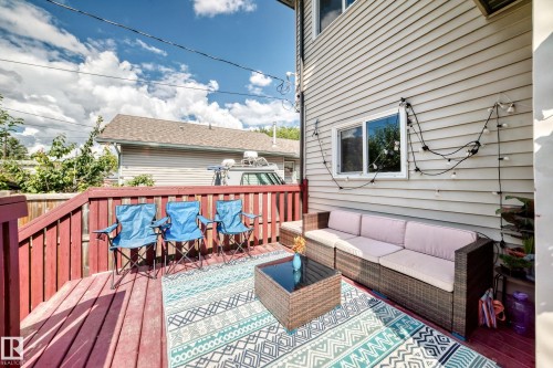 Expansive outdoor deck featuring wood flooring and a privacy fence - 12730 118 Street Nw, Edmonton, AB 