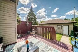 Expansive wood-finish deck with privacy fencing, offering direct access to the back building with exterior siding and a single entry door - 
