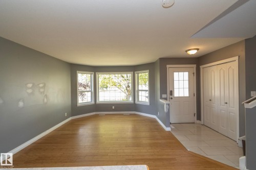Bay window, wood-finish flooring, tiled entry, panel front door, and bi-fold closet doors - 137 Michigan Street, Devon, AB 