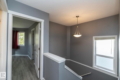 Neutral wall tones, wood-finish flooring, white trim, and an overhead light fixture - 137 Michigan Street, Devon, AB 