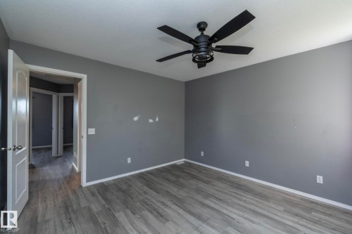 Wood-finish flooring, painted walls, ceiling fan with light fixture, and white trim accents - 137 Michigan Street, Devon, AB 