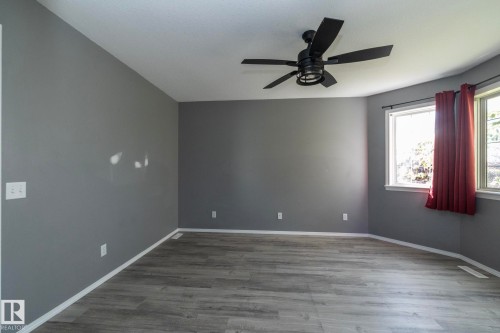 Wood-finish flooring, bay windows, contemporary ceiling fan, and grey painted walls - 137 Michigan Street, Devon, AB 