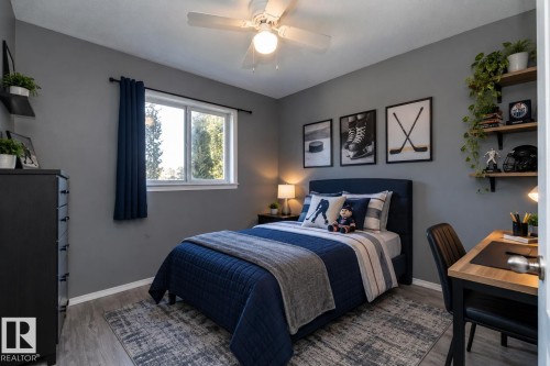 Wood-finish flooring with neutral wall tones, a ceiling fan with integrated lighting, and a window for natural light - 137 Michigan Street, Devon, AB 