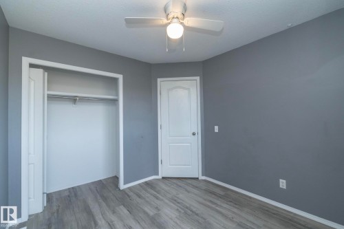 Wood-finish flooring, ceiling fan with integrated lighting, flat panel interior doors, and a built-in closet with hanging rod - 137 Michigan Street, Devon, AB 
