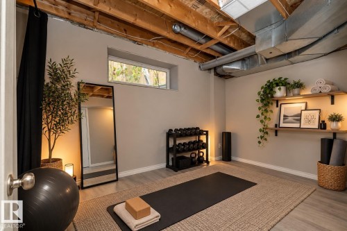 Finished room with wood-finish flooring, exposed ceiling joists, and a horizontal window - 137 Michigan Street, Devon, AB 