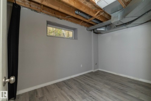 Finished walls with a neutral paint color, wood-finish flooring, and a horizontal window - 137 Michigan Street, Devon, AB 