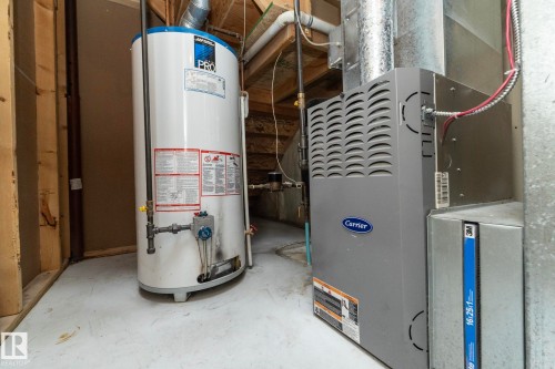 Utility space featuring a water heater and a Carrier furnace - 137 Michigan Street, Devon, AB 