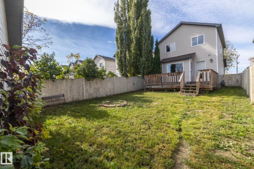 Fenced backyard featuring a wood deck, sliding glass door, and a two-story exterior with siding - 137 Michigan Street, Devon, AB 